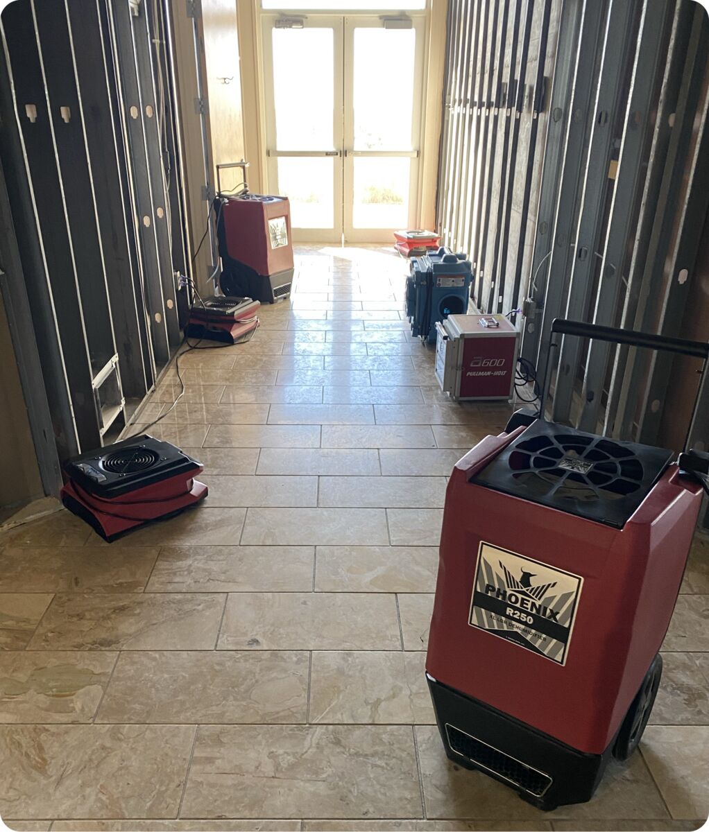 DRI Gulf Coast dehumidifier and air movers drying a hallway with the walls opened